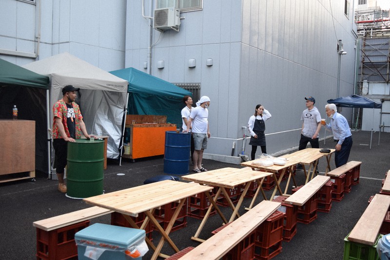営業開始へテント設営や提供メニューの準備を進める「旦過復興屋台村」の関係者ら=北九州市小倉北区で2022年5月27日午後6時50分、青木絵美撮影