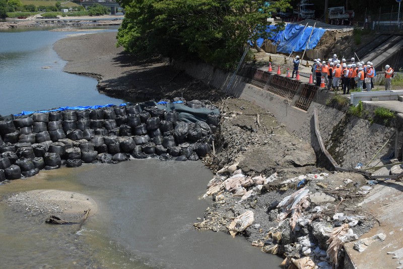 土のうで囲われた穴の付近を視察する委員ら=愛知県豊田市の明治用水頭首工で2022年6月2日午前10時58分、酒井志帆撮影