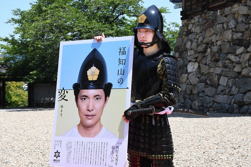 ポスターで「福知山の変」をPRする秋山蒼さん=福知山市の福知山城で2022年6月2日午前10時45分、綾井まどか撮影