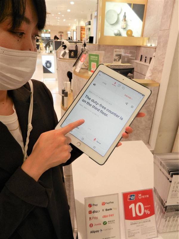 訪日客向け翻訳アプリの使い方を確認する百貨店の従業員=東京都中央区銀座3の松屋銀座で2022年6月7日午後1時51分、道下寛子撮影