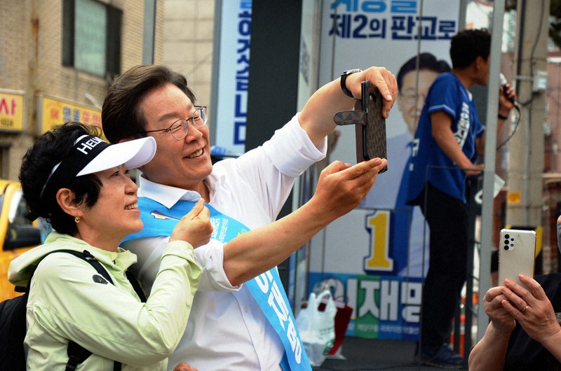 投票日が迫る中、有権者との記念撮影に応じる李在明氏=韓国西部・仁川市内で2022年5月30日、坂口裕彦撮影