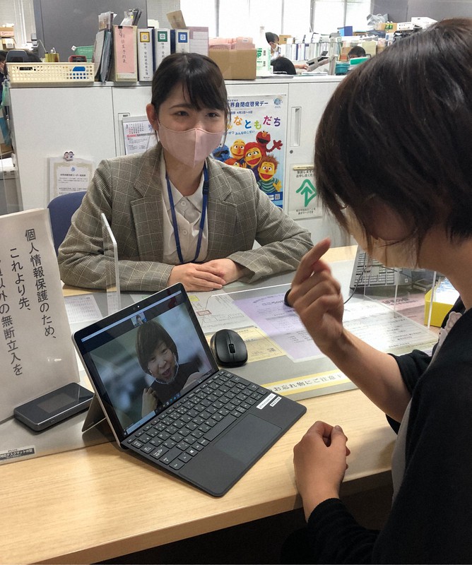 聴覚障害者がタブレット端末に映し出された手話通訳者を介して市職員に意思を伝えることができる=2022年4月、反田昌平撮影
