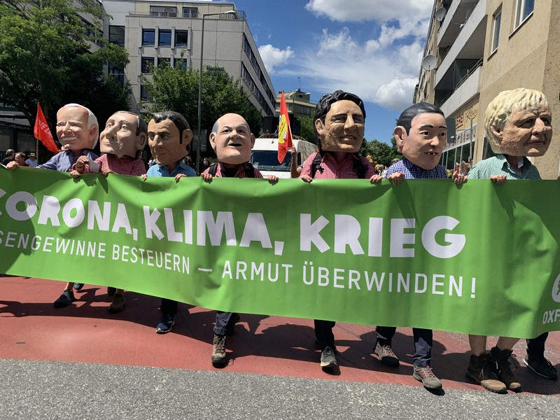 主要7カ国(G7)首脳の似顔絵マスクをかぶって各国の気候変動対策などに抗議する人々=独南部ミュンヘンで2022年6月25日午後1時47分、念佛明奈撮影