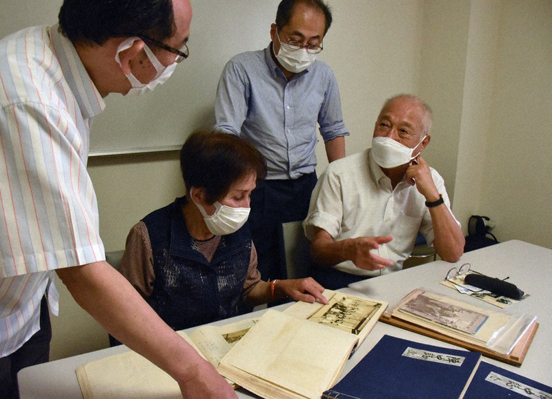 陣中日誌を前に話す親族と貴志俊彦教授(左端)=京都市上京区で、中島怜子撮影