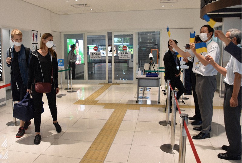 佐賀空港に到着して民間団体や県の関係者から歓迎を受けるウクライナ避難民の親子(左端)