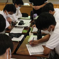 各党と自分の意見の一致度が分かる「ボートマッチ」の質問に答える生徒らと華井裕隆教諭（中央奥）＝さいたま市で2022年6月30日、岡礼子撮影