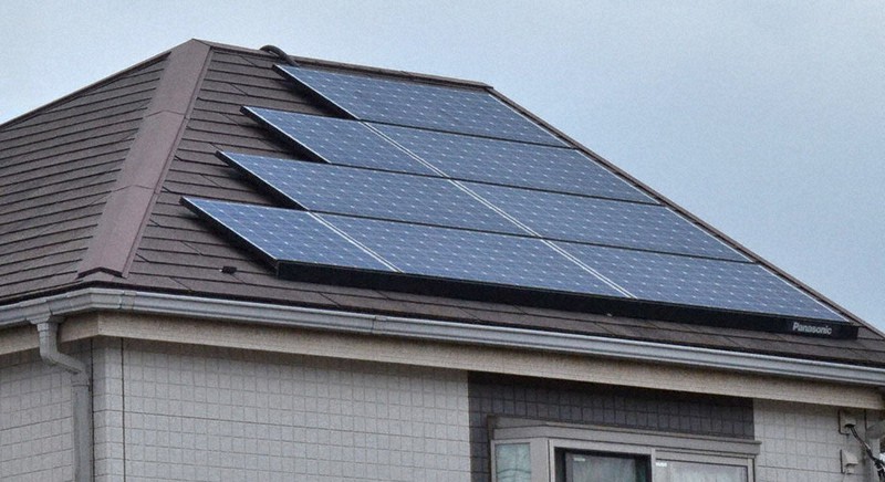 屋根に太陽光発電パネルを設置した戸建ての民家=都内で