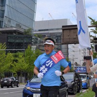 ランニングで有権者にアピールする小林氏＝新潟市中央区で2022年6月26日、内田帆ノ佳撮影