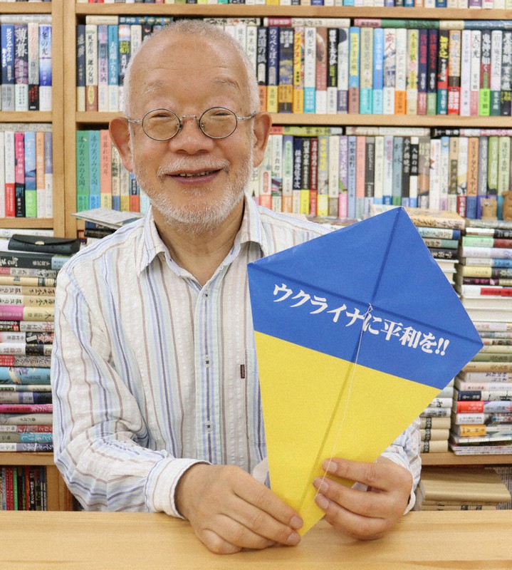 ウクライナ国旗と同色のハタを持ち、曲作りへの応募を呼び掛けるの松原さん