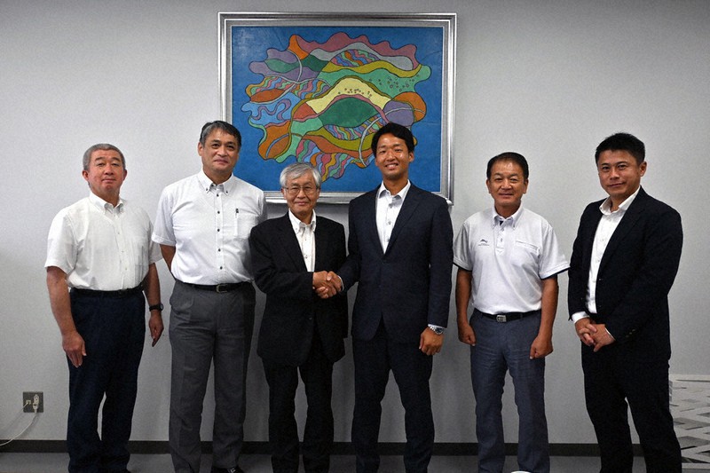 東京ドームでの勝利を期して握手を交わす徳橋曜学部長(左から3人目)と西納敦史投手(右から3人目)=富山市五福の富山大で、青山郁子撮影