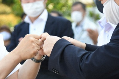 支持者とグータッチをする候補者＝松江市で、目野創撮影