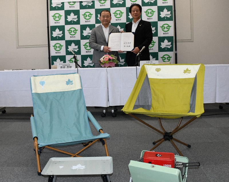 協定を結んだ柴田茂樹社長(左)と西村和平市長。手前は気球マークが入ったふるさと納税返礼品のロゴスコーポレーション商品=兵庫県加西市で、阿部浩之撮影