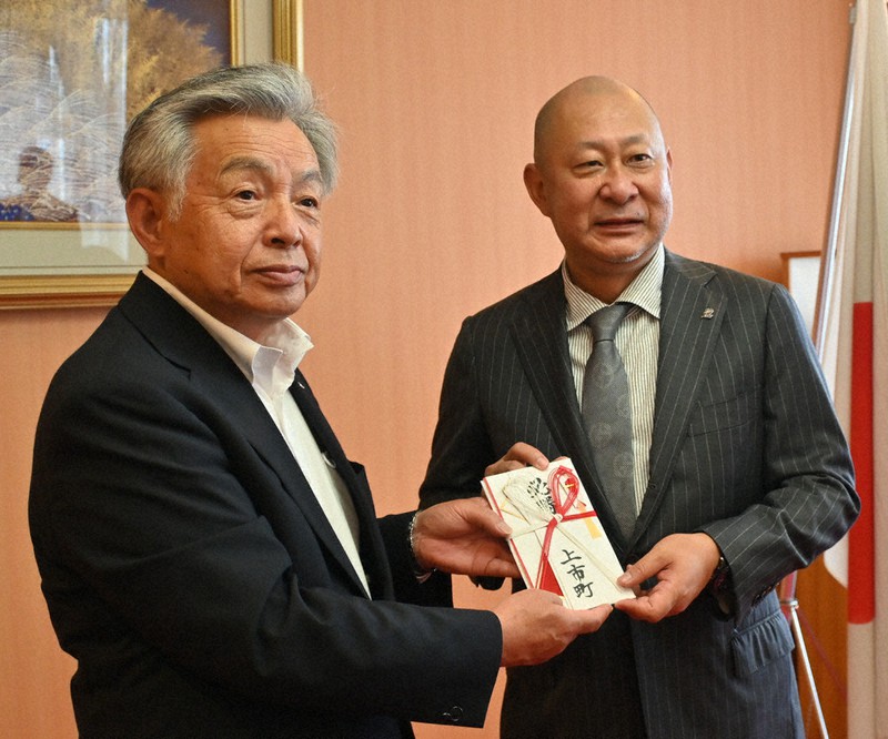 伊東伸会長兼社長(右)に激励金を手渡す中川行孝町長=富山県上市町法音寺の町役場で、青山郁子撮影