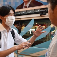 候補者に若者向けの政策について尋ねる中村さん（左）＝東京都世田谷区で2022年6月30日午後5時37分、南茂芽育撮影（画像の一部を加工しています）