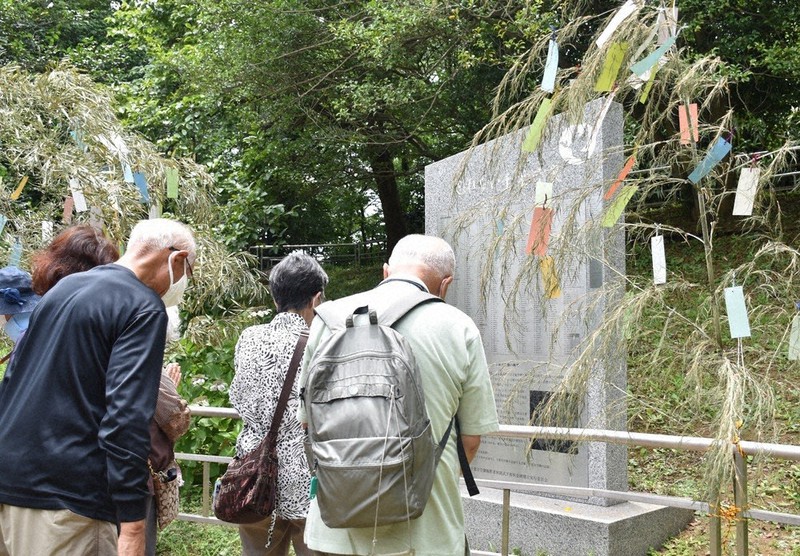 祈念碑の前で黙とうする遺族ら。千葉市立本町小学校の児童の短冊がかかったササも飾られた=同市中央区で2022年7月7日午、真田祐里撮影