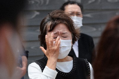 「女川いのちの広場」でお披露目の会が開かれ、長男健太さんの遺影を手にあいさつした田村孝行さんの妻・田村弘美さん（59）。「私たちのようにつらく悲しい思いをする家族はもう作らないでほしい」と涙を流した