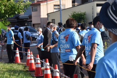 演説する岸田首相の背後をロープで囲い警備するボランティアと、周囲を警戒する警察官ら＝新潟市秋葉区で2022年7月9日、露木陽介撮影