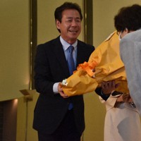 確実の報を受け、支援者から花束を受け取る小鑓隆史氏＝大津市におの浜4のびわ湖大津プリンスホテルで2022年7月10日午後8時32分、菅健吾撮影