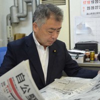 参院選で5選したことを報じる新聞を読む桜井充氏＝仙台市宮城野区の事務所で2022年7月11日、土江洋範撮影