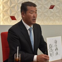 3期目の抱負として「勇往邁進」と書いた色紙を持つ石井浩郎氏＝秋田市中通1で2022年7月11日、猪森万里夏撮影
