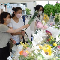 安倍晋三元首相が銃撃された現場近くの献花台を訪れる人たち＝奈良市西大寺東町で、村瀬達男撮影