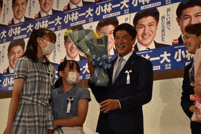 家族から花束を受け取り、当選を喜ぶ小林氏＝新潟市中央区で2022年7月10日、内田帆ノ佳撮影