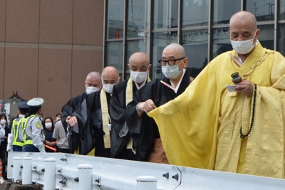 安倍晋三元首相の銃撃現場に砂をまく西大寺の僧侶＝奈良市で、塩路佳子撮影