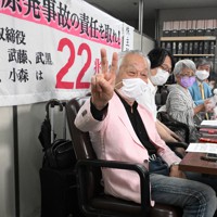 記者会見終了後、笑顔を見せる弁護団の河合弘之弁護士（手前）ら＝東京都千代田区で2022年7月13日午後5時35分、西夏生撮影