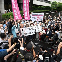 東京電力福島第1原発事故を巡る株主代表訴訟の判決後、「責任認める」などと書かれた紙を掲げ喜ぶ原告側関係者＝東京都千代田区の東京地裁前で2022年7月13日午後3時47分、西夏生撮影