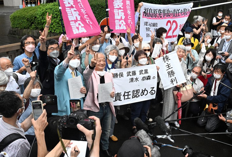 東京電力福島第1原発事故を巡る株主代表訴訟の判決後、「責任認める」などと書かれた紙を掲げ喜ぶ原告側関係者＝東京都千代田区の東京地裁前で2022年7月13日午後3時47分、西夏生撮影