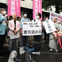 東電の旧経営陣の責任を認める東京地裁の判決を受け、報道陣の囲み取材に応じる弁護団と原告ら＝東京都千代田区で2022年7月13日午後3時52分、西夏生撮影