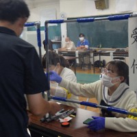 投票所の受け付け業務を体験する樹徳高3年の佐藤琴美さん（右）＝群馬県桐生市で2022年7月10日、大澤孝二撮影