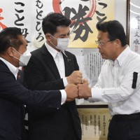 当選が決まり、自民党県連の柴山昌彦会長（中央）らとグータッチをする西田実仁氏（右）＝さいたま市浦和区で2022年7月10日午後10時48分、清藤天撮影