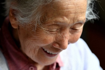 取ってきたササを仕分けながら笑顔を見せる桑田ミサオさん＝青森県五所川原市金木町で2022年6月30日、北山夏帆撮影