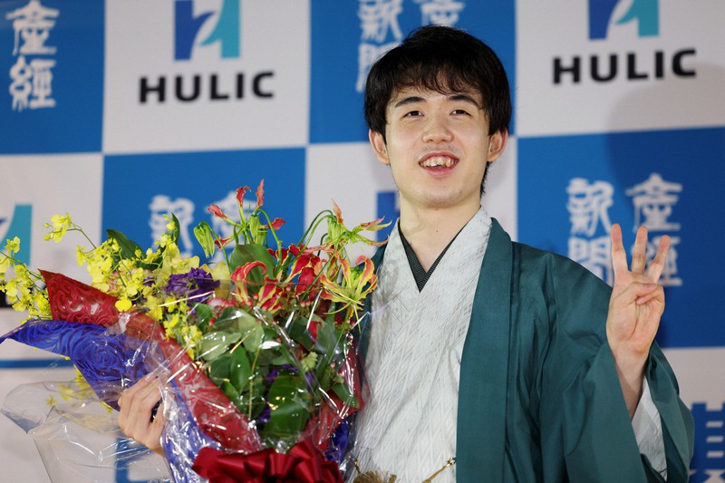 棋聖戦を3連覇し、花束を手に笑顔を見せる藤井聡太棋聖＝名古屋市中区で2022年7月17日午後8時半、兵藤公治撮影
