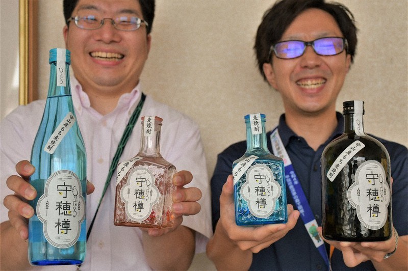 守山市産もち麦を使った焼酎「守穂樽」を手にする市農政課の職員=滋賀県の森山市役所で2022年7月28日午後3時47分、礒野健一撮影