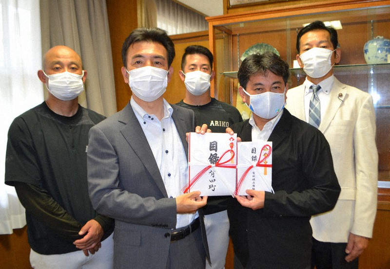 有田工で松尾・有田町長(前列右)から甲子園出場を祝う二つの目録を受け取った山崎校長(同左)。後列左端が梅崎監督