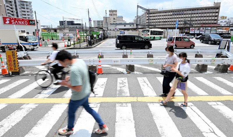 安倍晋三元首相が銃撃された事件から1カ月を迎えた現場付近を通る人たち=奈良市で2022年8月8日午後0時20分、川平愛撮影
