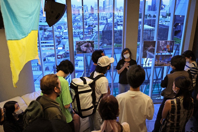 ハルキウ(ハリコフ)の写真が展示さ 薮れた会場で、町を紹介するサーシャ・カベリーナさん(奥)=渋谷区で