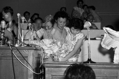 第2回原水爆禁止世界大会で、母親スガさんに抱えられて登壇した渡辺千恵子さん＝長崎市で1956年8月9日