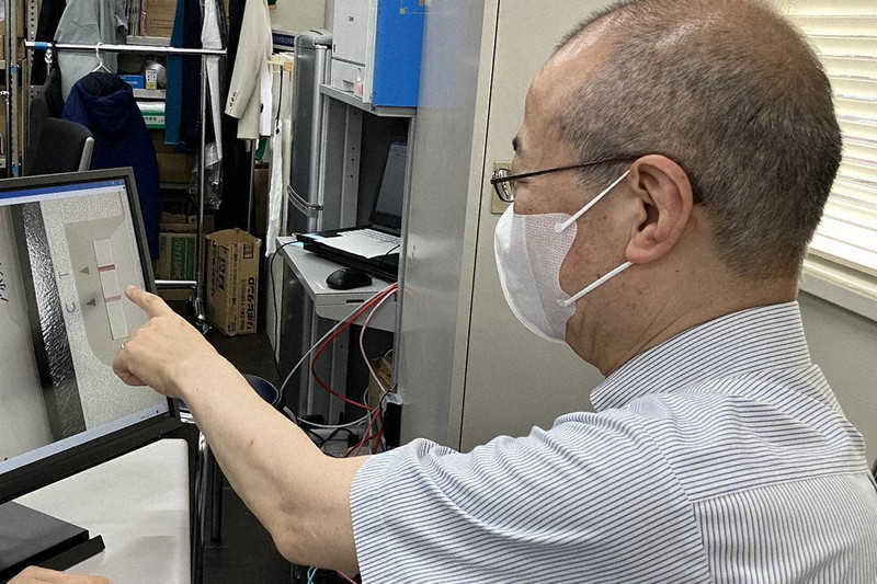 検査結果を見ながら、陽性の確定診断をする埼玉県職員の医師=さいたま市浦和区の県庁で2022年8月2日、岡礼子撮影