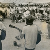 ハンパク会場では、そこここでフォークソングも歌われた。当時の毎日新聞は「広場のあちこちで&ldquo;歌と対話&rdquo;の輪が夜を徹して続いた」と伝える＝1969年8月撮影