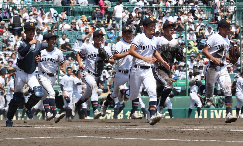 【九州国際大付-高松商】九州国際大付との接戦に勝ち、笑顔でアルプス席に駆け出す高松商ナイン=阪神甲子園球場で2022年8月15日、滝川大貴撮影