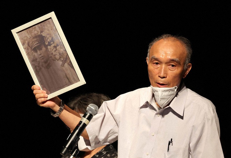証言集会で父慶次郎さんの写真を手に語る黒井秋夫さん=東京都武蔵村山市で2022年8月7日、幾島健太郎撮影