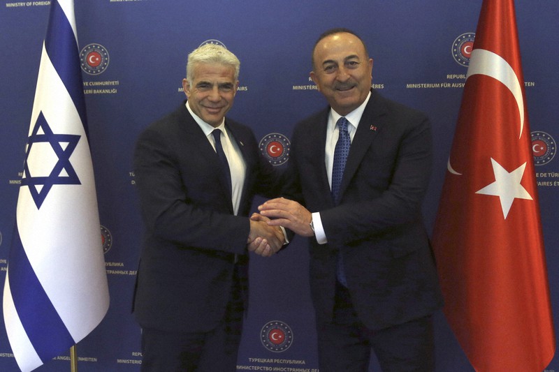 トルコのチャブシオール外相(右)と握手するイスラエルのラピド外相(現首相)=アンカラで6月23日、AP