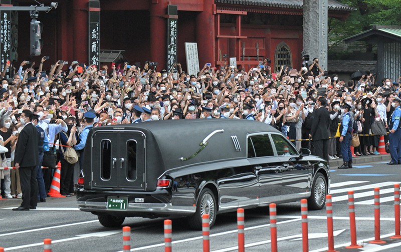 葬儀を終え、安倍晋三元首相のひつぎを乗せた霊きゅう車を見送る大勢の人たち=東京都港区で2022年7月12日、手塚耕一郎撮影