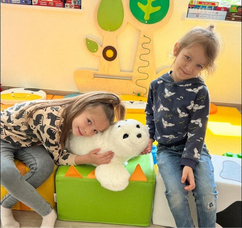 パロを抱きしめて笑顔を見せる子どもたち=ポーランドのマゾフシェ県神経精神医学センターの小児病院で、同センター提供