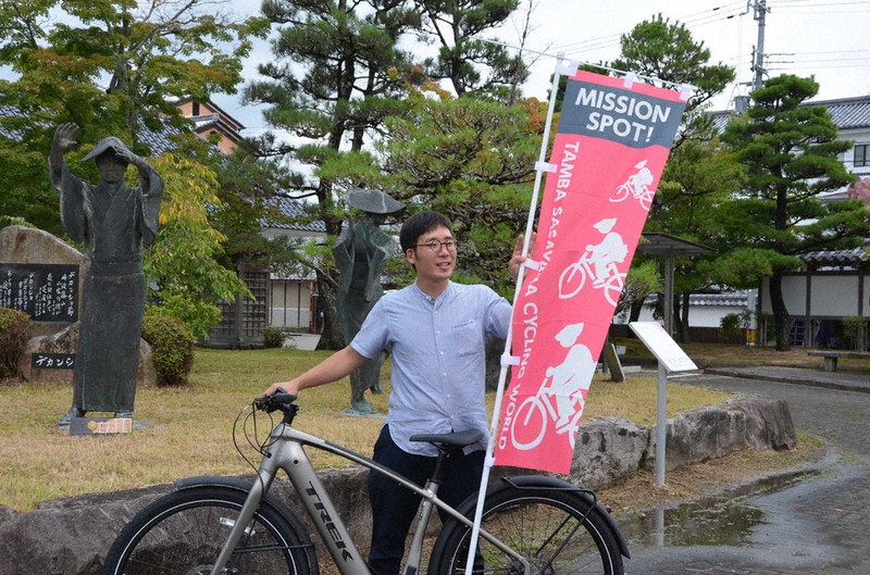 イベント協力店舗に掲げられているのぼりを手にする村上大輔さん=兵庫県丹波篠山市北新町の市役所で、丸井康充撮影