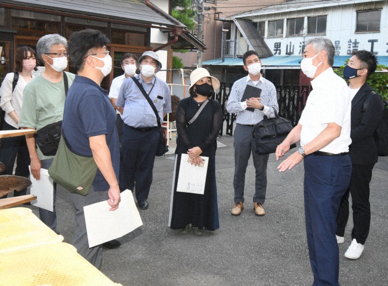 震災後の酒造りについて大阪府の経営者らに語る男山本店の菅原昭彦社長(右から2人目)=宮城県気仙沼市の男山本店の酒蔵で2022年7月26日、高橋秀郎撮影