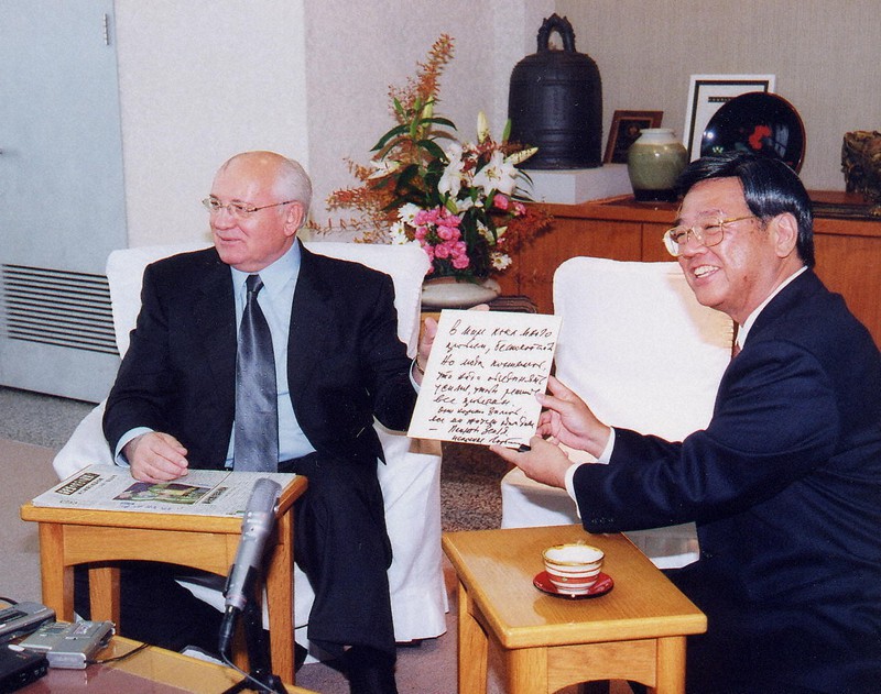 那覇市を訪問し、翁長雄志市長(当時)に色紙をプレゼントするゴルバチョフ氏(左)=2001年11月14日(那覇市提供)